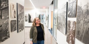 Person walking through hallway looking at art and photographs on the walls