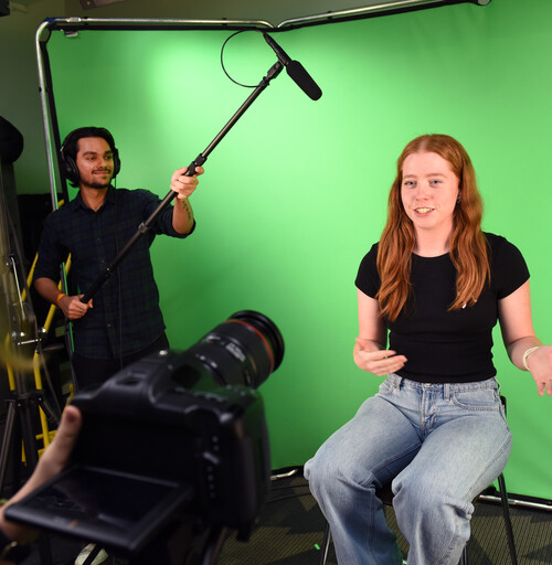 Students in the ASU Library Makerspace Audio Visual Studio with a camera, microphone and green screen.